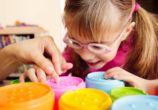 Young girl with additional needs, smiling and learning.